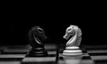 Black and White chess knights facing off each other