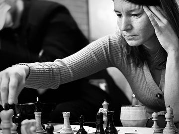 Chess player deep in thought making a move-