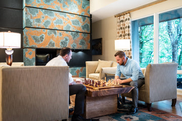 two men playing chess on a coffee table