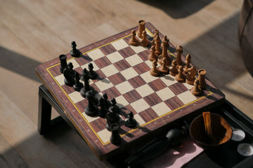 Small travel chess set on a small stool- Denis Volkov-Unsplash