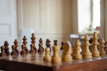 A chessboard with brown and white/yellowish pieces