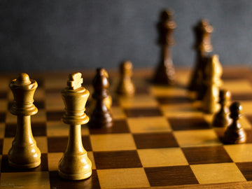 white-chess-king-and-queen-with-some-black-pieces-enrico-motta-unsplash